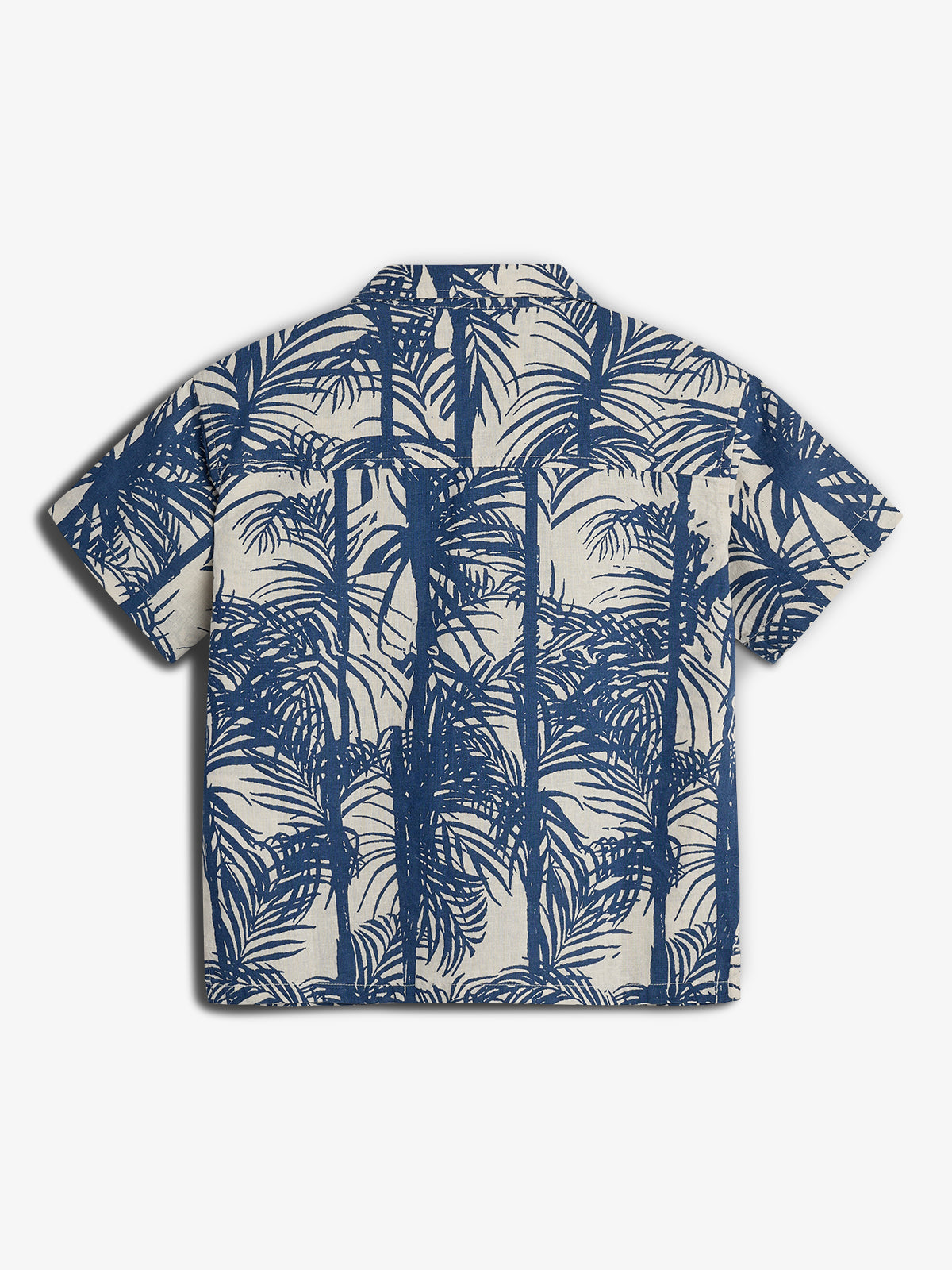 A short-sleeved, collared shirt displays a blue palm tree pattern on a beige background, laid flat against a plain white surface.
