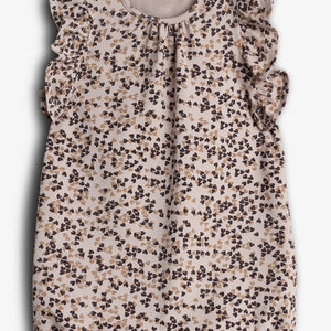 A floral-patterned baby romper with ruffled sleeves is displayed against a plain background. The text inside reads, "Pomp de Lux ORGANIC COTTON."