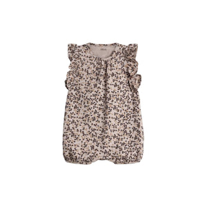 A floral-patterned baby romper with ruffled sleeves is displayed against a plain background. The text inside reads, "Pomp de Lux ORGANIC COTTON."