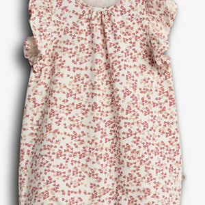A white baby romper decorated with a pink strawberry pattern, featuring ruffled sleeves. The label reads "PURE.LUX ORGANIC COTTON," suggesting an emphasis on organic materials.