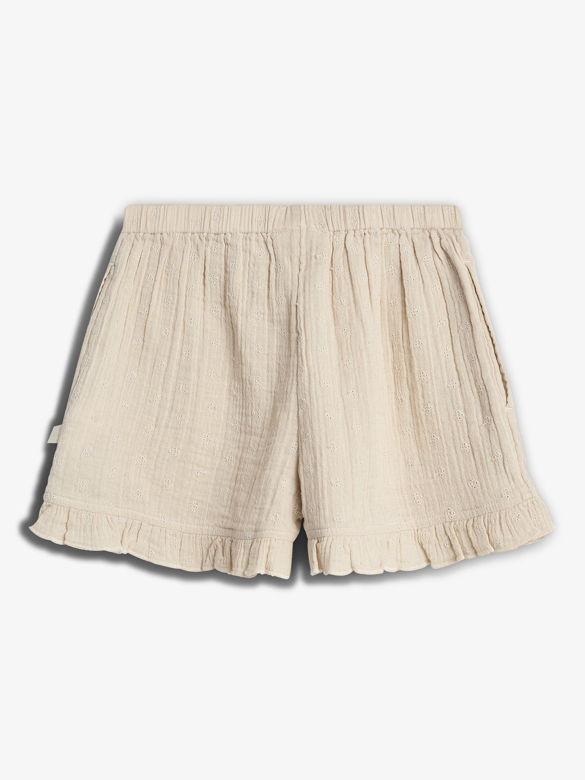 Cream-colored shorts display embroidered floral patterns with an elastic waistband and ruffled hem, lying flat against a plain white background.