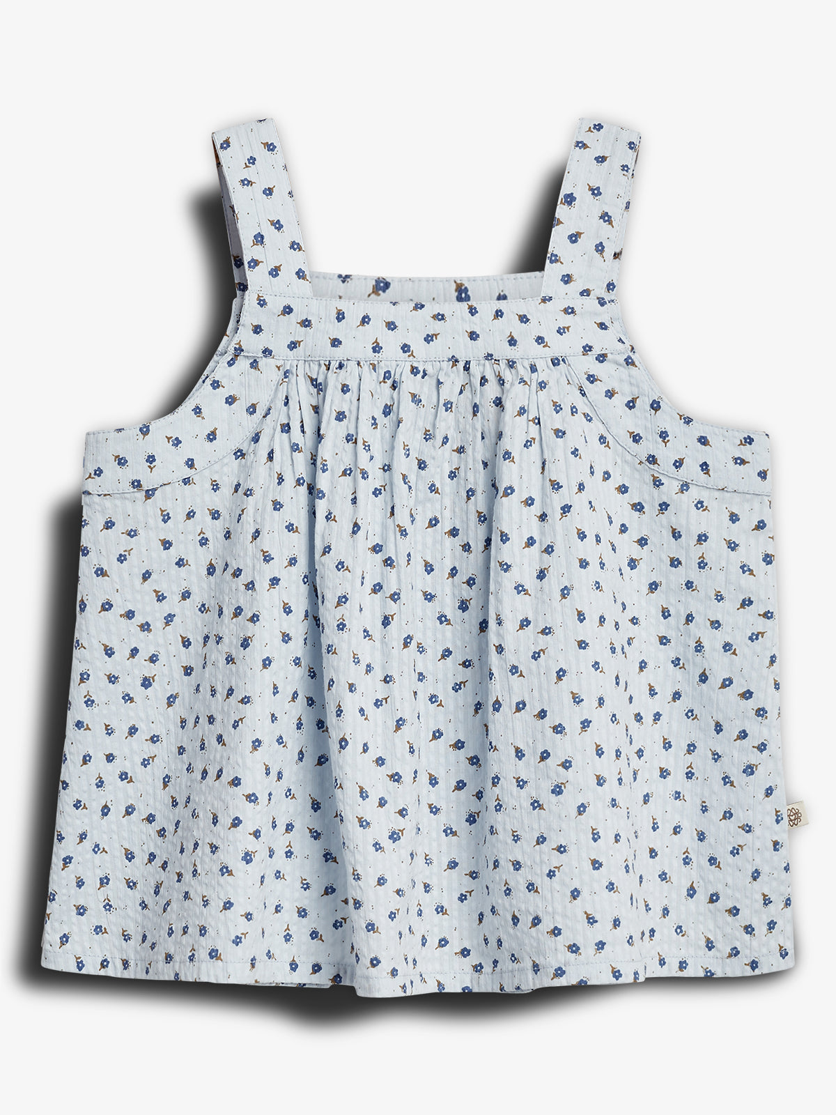 A light blue sleeveless top with thin straps, adorned with a pattern of small blue flowers, displayed against a plain white background.