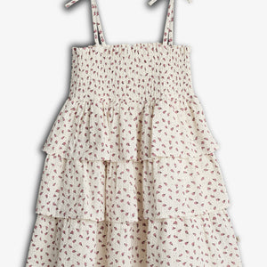 A floral-patterned, tiered dress with tied shoulder straps, featuring shirred bodice and layered ruffle skirt, displayed against a plain white background.