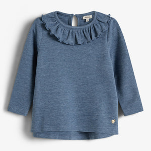 A blue long-sleeve toddler shirt with a ruffled collar hangs against a plain background. It features a small gold heart detail at the bottom.