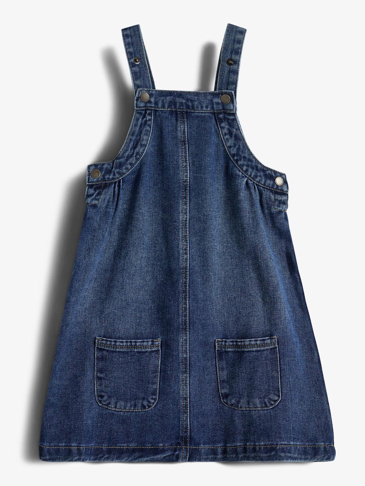 A blue denim pinafore dress with two straps and front pockets, laid flat against a white background.