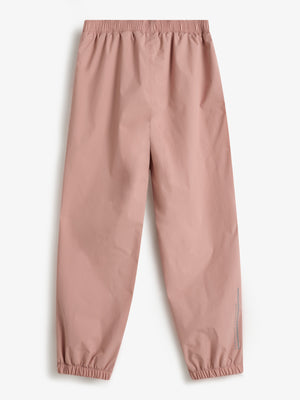 Pink elastic-waist pants lie flat on a white background, featuring gathered cuffs. Printed text on the right leg reads "polder day rainwear," adding a functional design element.